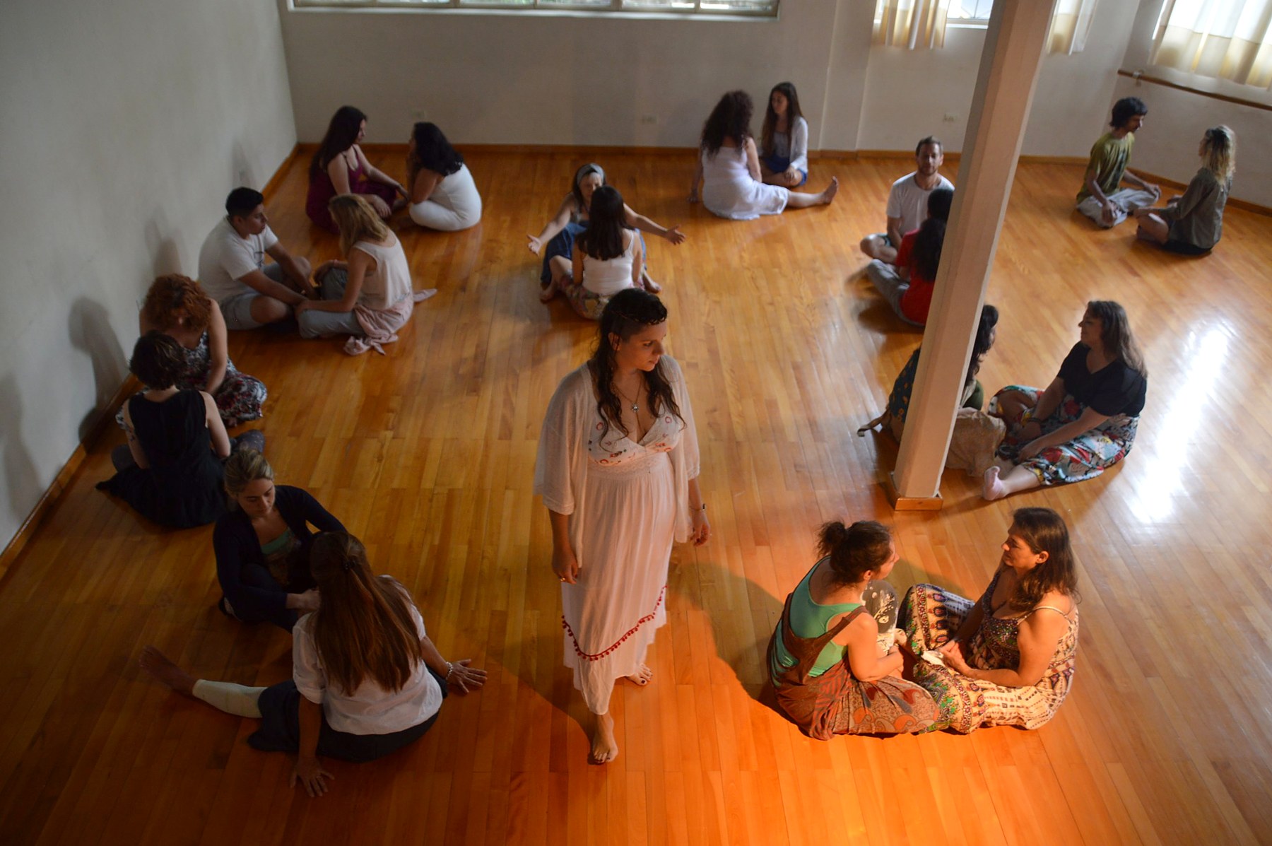 Grupo practicando en parejas en la sala durante un curso de Reiki Vocal
